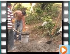 Hondurans mix cement at the water collection site.