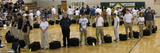 Missioners stand amid bags, which have been placed in the shape of a heart